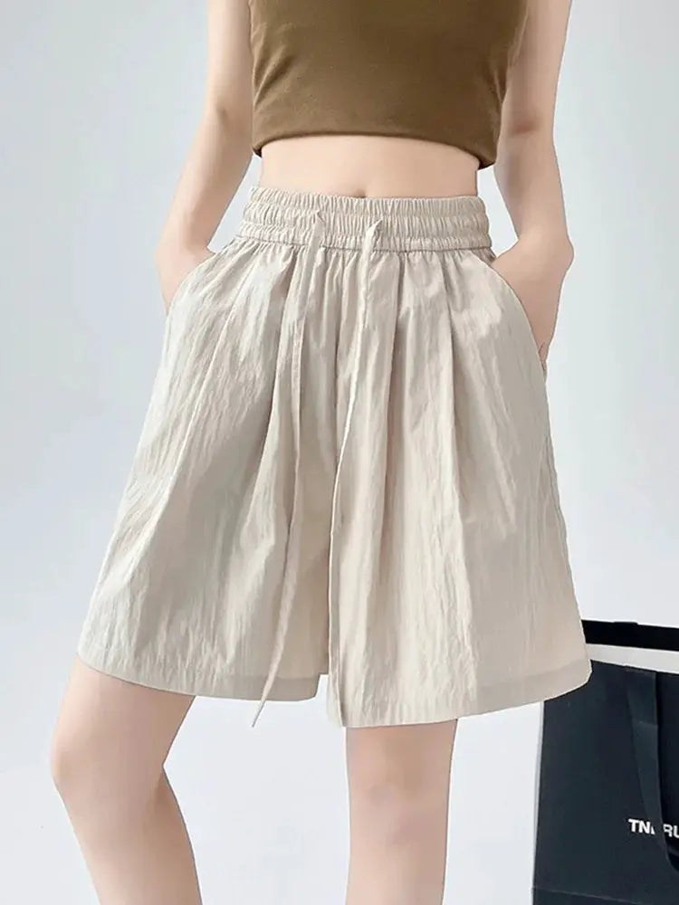Women's beige high-waist loose shorts with two pockets and elastic waistband