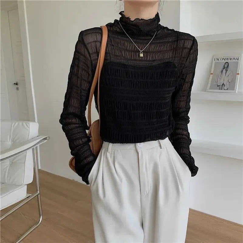Black sheer lace mesh long-sleeve blouse, see-through top with high neckline, paired with beige trousers
