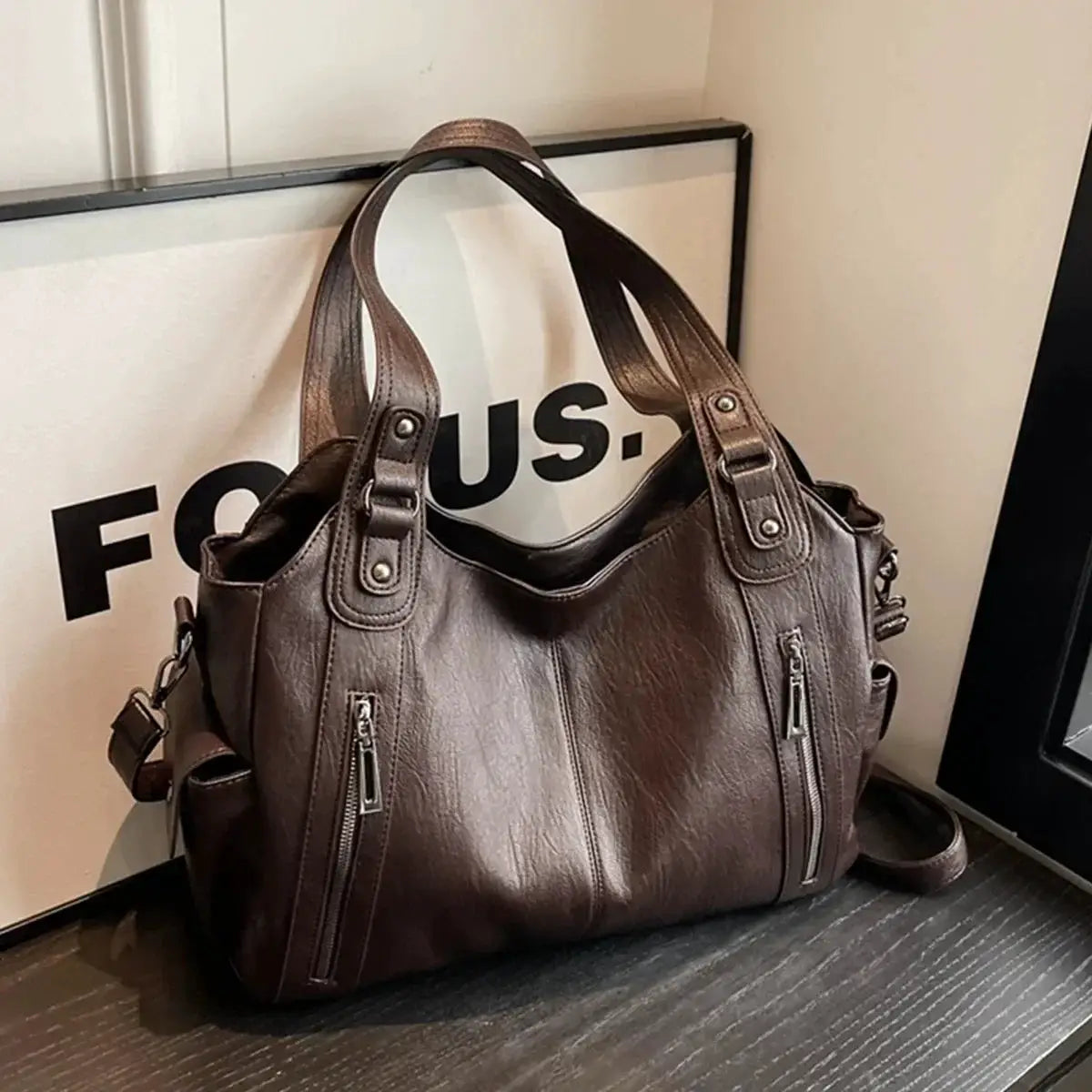 Brown PU leather women's shoulder bag with dual top handles and two front zipper pockets.