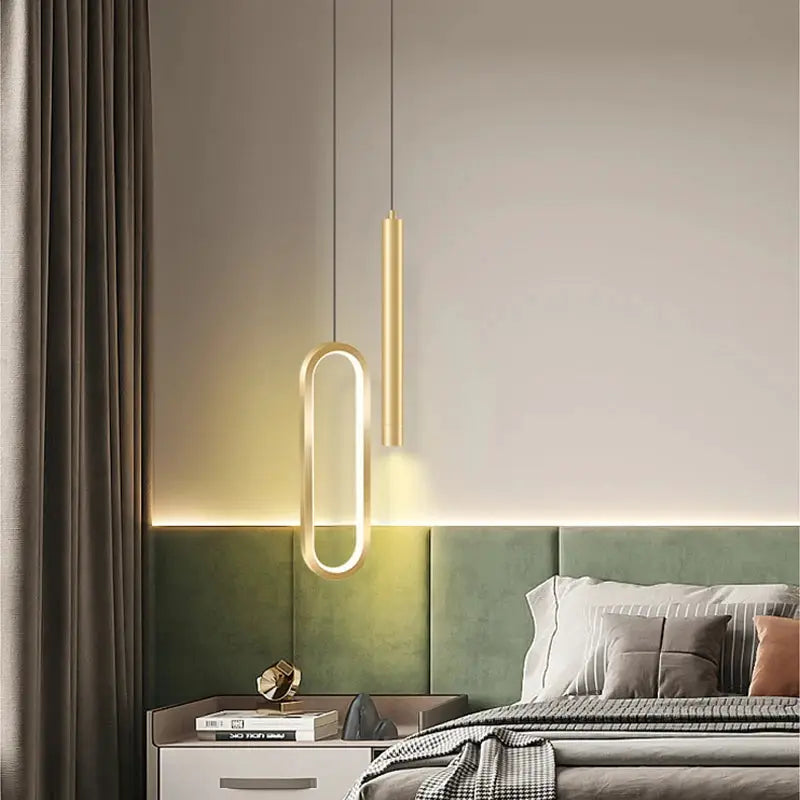 Nordic LED pendant light set with brass oval ring and slim cylindrical pendant, warm white glow over bedroom.