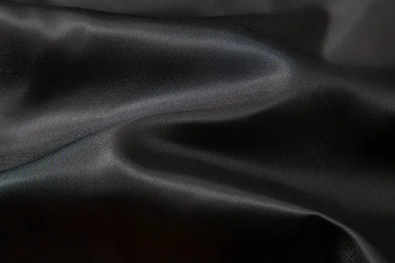Black satin fabric close-up texture for formal vests and waistcoats