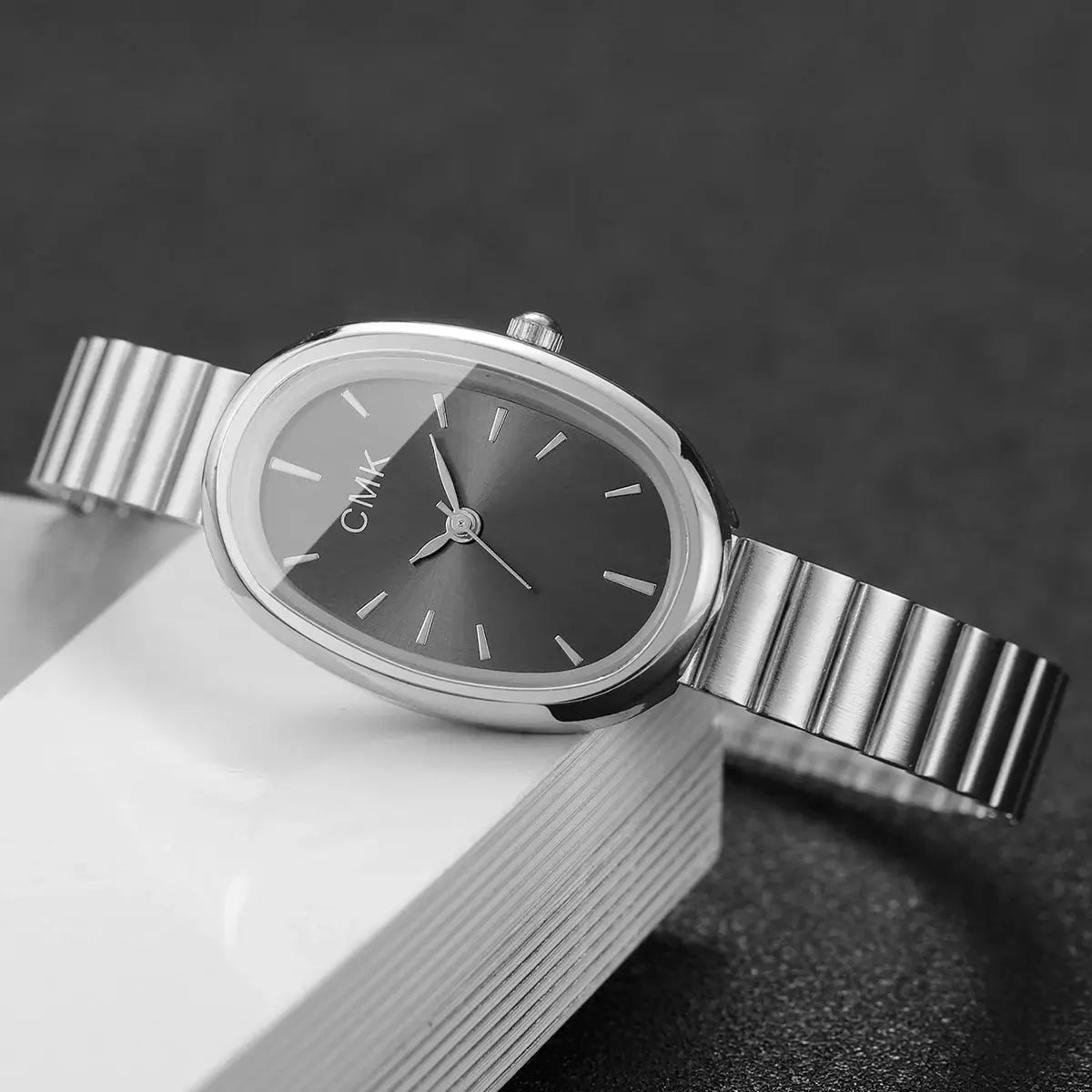 Women's silver oval-dial quartz watch with ultra-thin metal strap; CMK logo visible