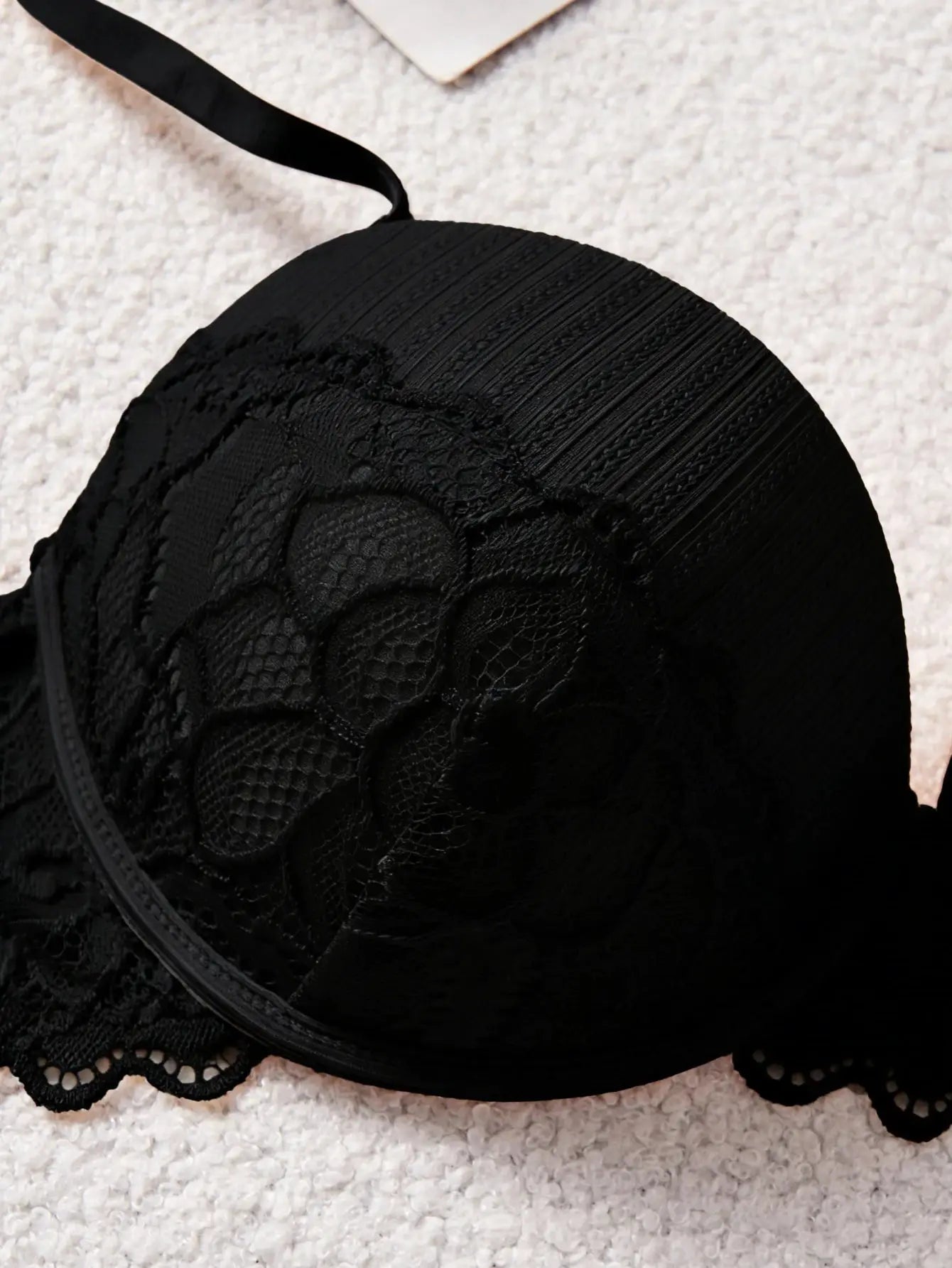 Black lace bra with floral pattern and scalloped edge.