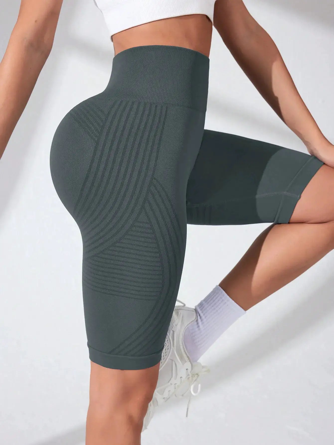 Women's high-waisted seamless yoga shorts in dark teal with ribbed panels and stretch fabric