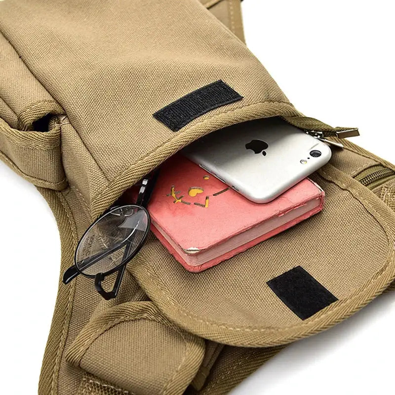 Men's canvas drop-waist fanny pack in tan; shows pink notebook, glasses, and smartphone in the pocket