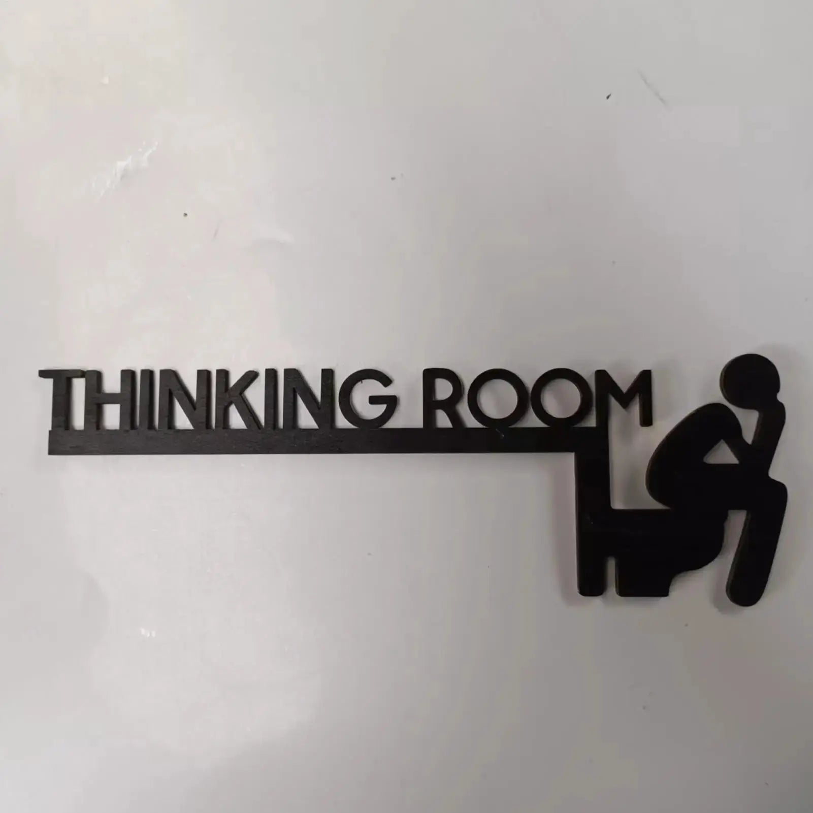 Door sign thinking room, black wood letters spelling THINKING ROOM with a seated silhouette.
