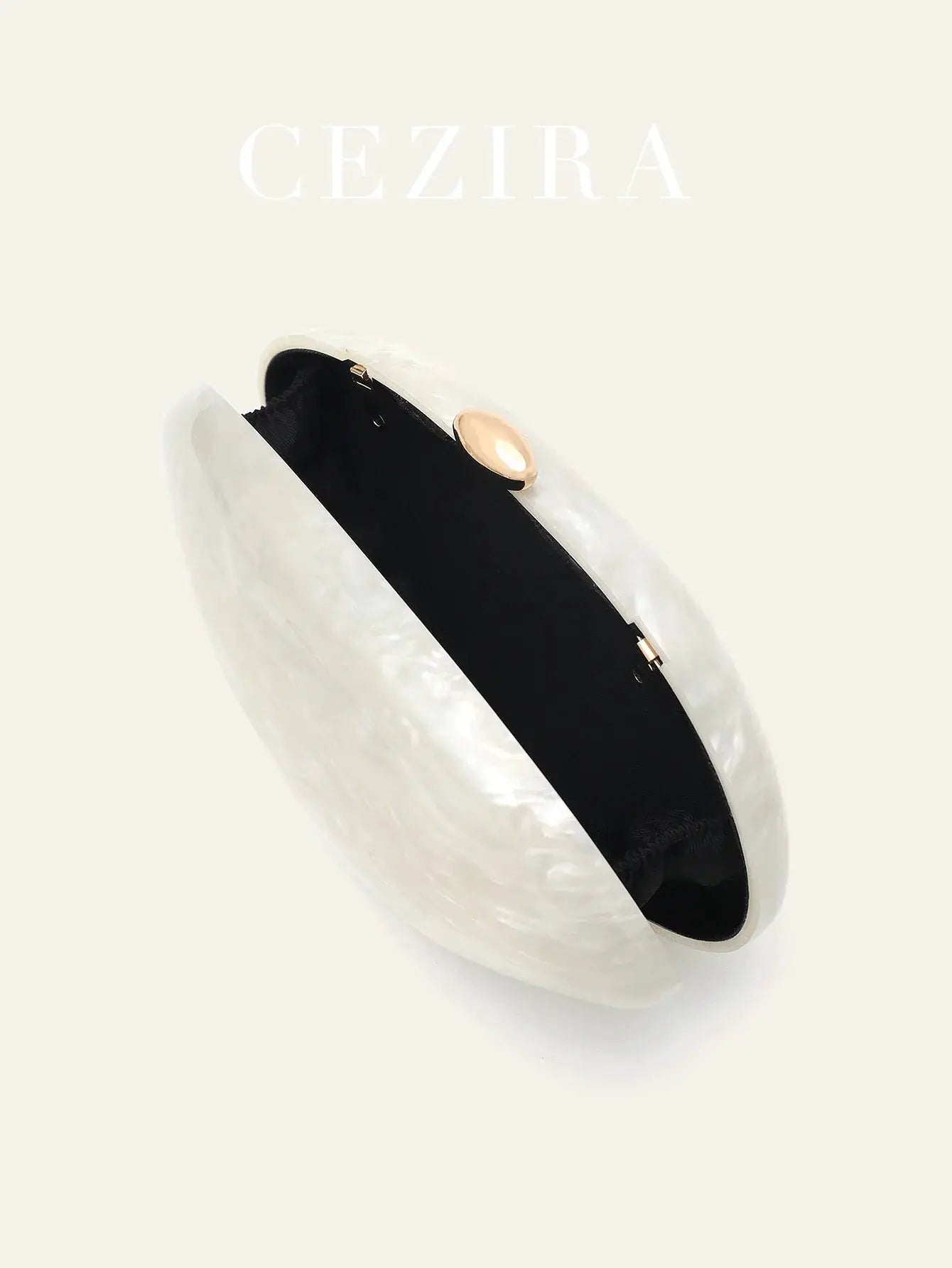 Shell-shaped acrylic clutch by Simples Market with long chain; clear shell, black interior, gold-tone clasp.