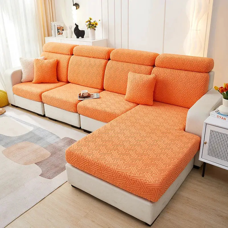 Sofa slipcovers in orange jacquard on a beige sectional with chaise