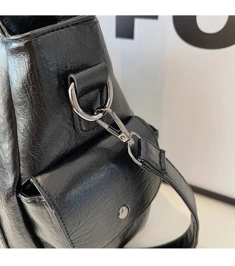Shoulder bag, black leather with silver hardware and detachable strap.