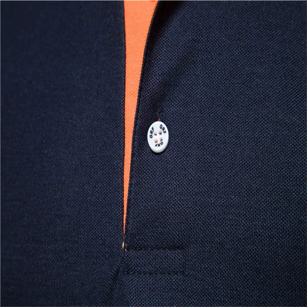 Men's navy polo shirt with orange placket trim and white button detail.