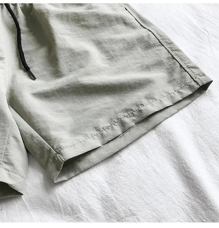 Simples Market men's swim shorts in light gray-green with black drawstring, board short style