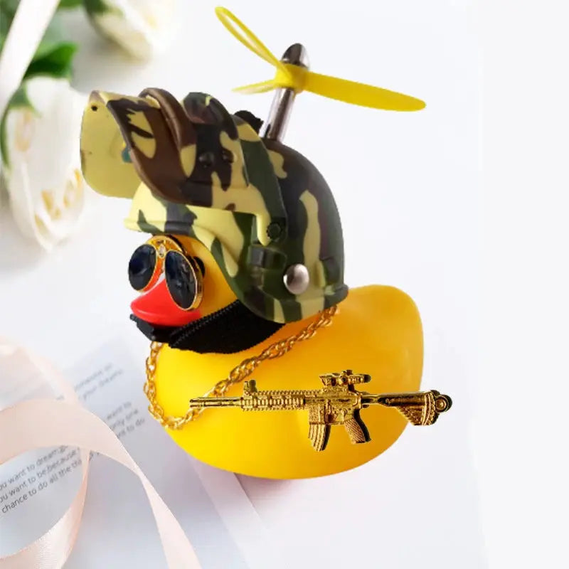 Rubber duck car decor: yellow duck wearing camo helmet, sunglasses, and gold gun charm
