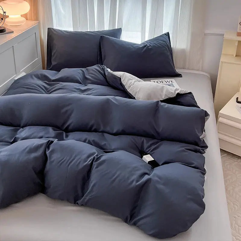 Duvet set by Simples Market, navy blue two-sided brushed fabric with pillowcases on a bed.