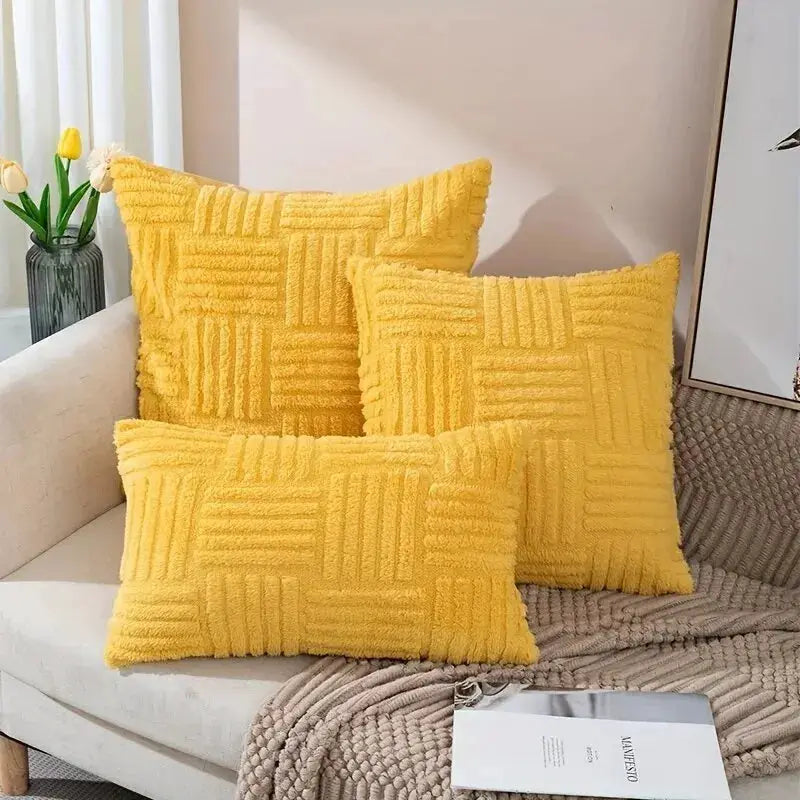 3 yellow boho faux-fur throw pillows with a textured square pattern on a sofa