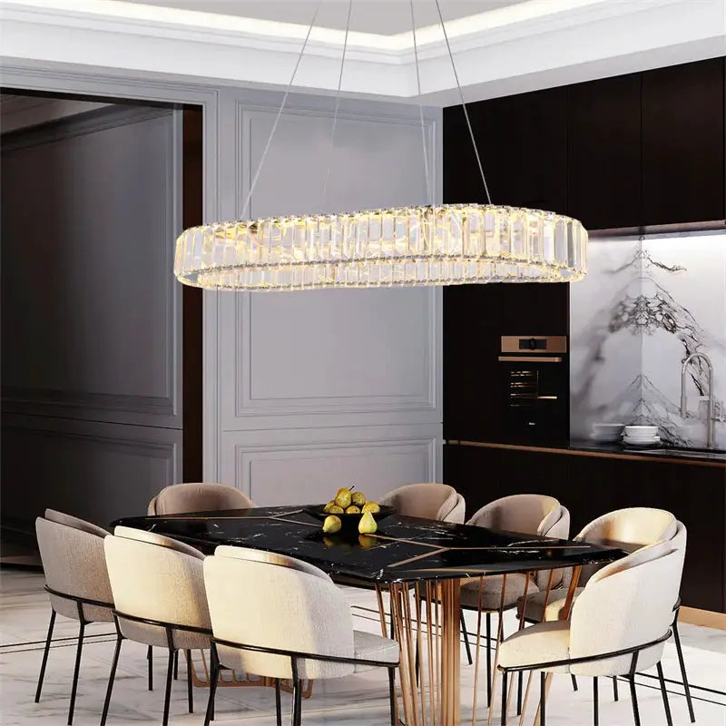 Modern crystal ring chandelier pendant lighting with chrome lustre finish over a black marble dining table.