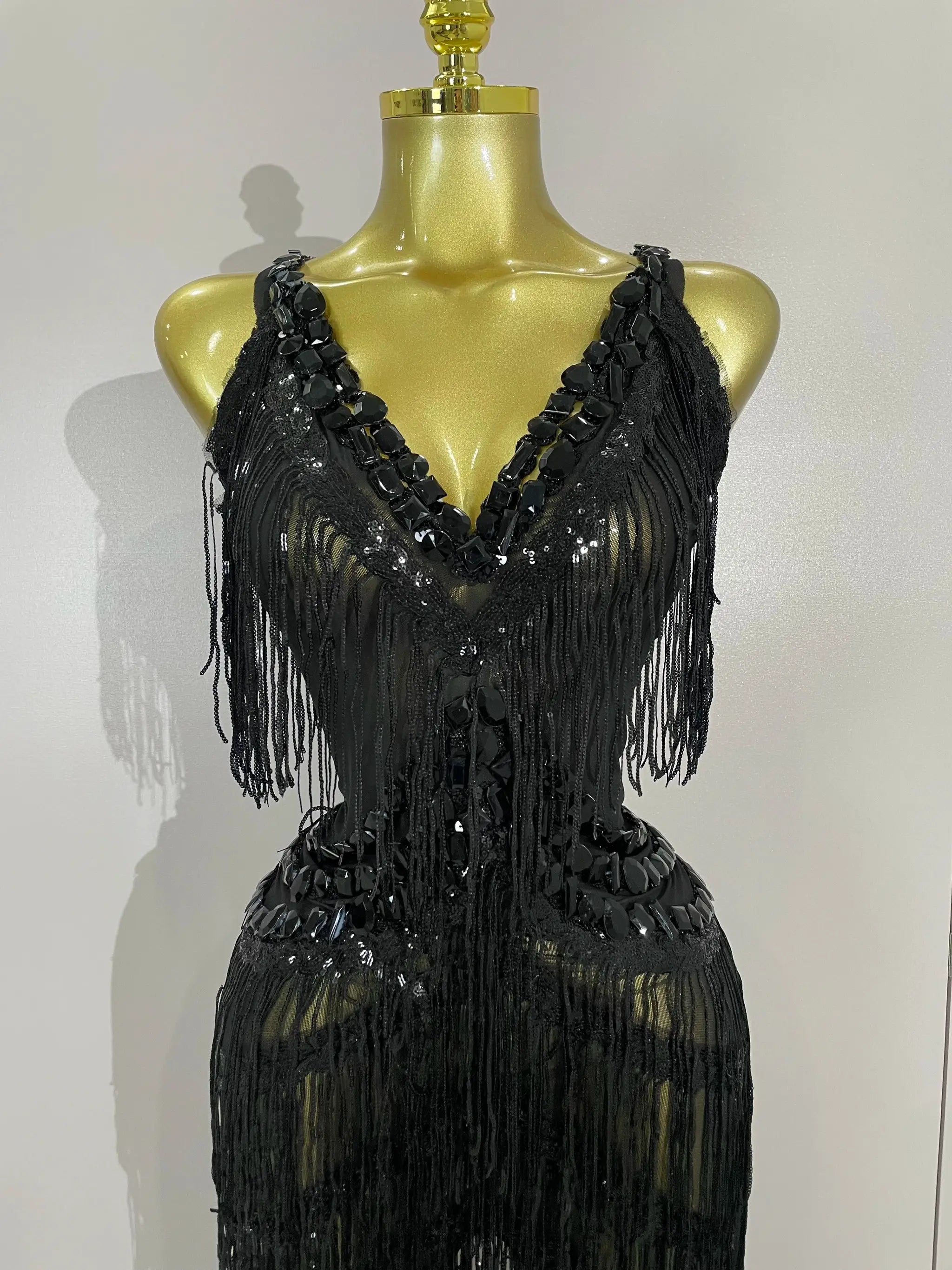 Jumpsuit with black rhinestones, fringe and sequins on mannequin