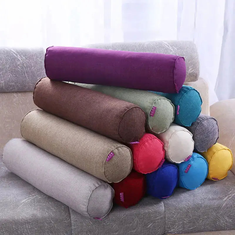 Cotton-linen cylindrical bolster pillow cases in assorted colors stacked on a sofa for home decor and lumbar support
