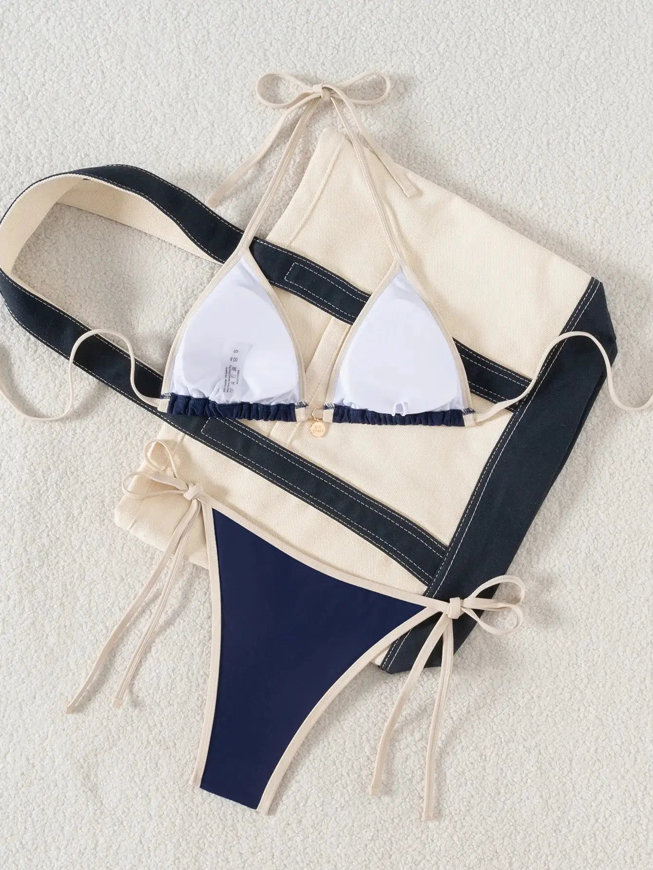 Simples Market two-piece bikini set with beige and navy color blocking, white triangle cups, and tie-side bottoms.