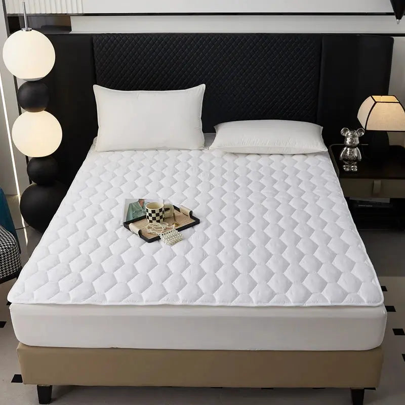 Waterproof quilted mattress protector topper, white and thickened, breathable, on a bed with a black headboard.