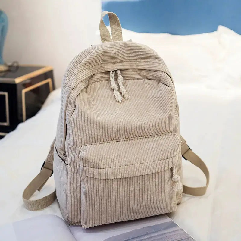 Kids corduroy backpack by Simples Market with front pocket and drawstring closure.