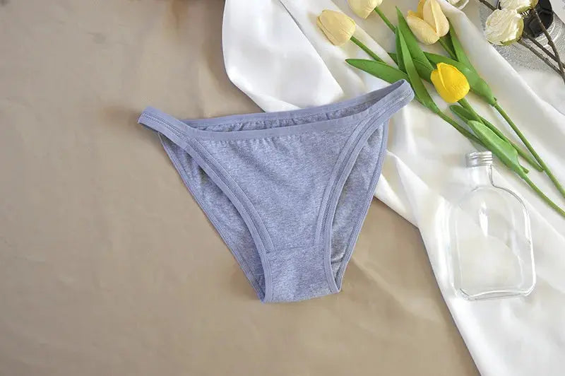 Gray cotton women's bikini briefs; solid color underwear displayed on a beige backdrop.