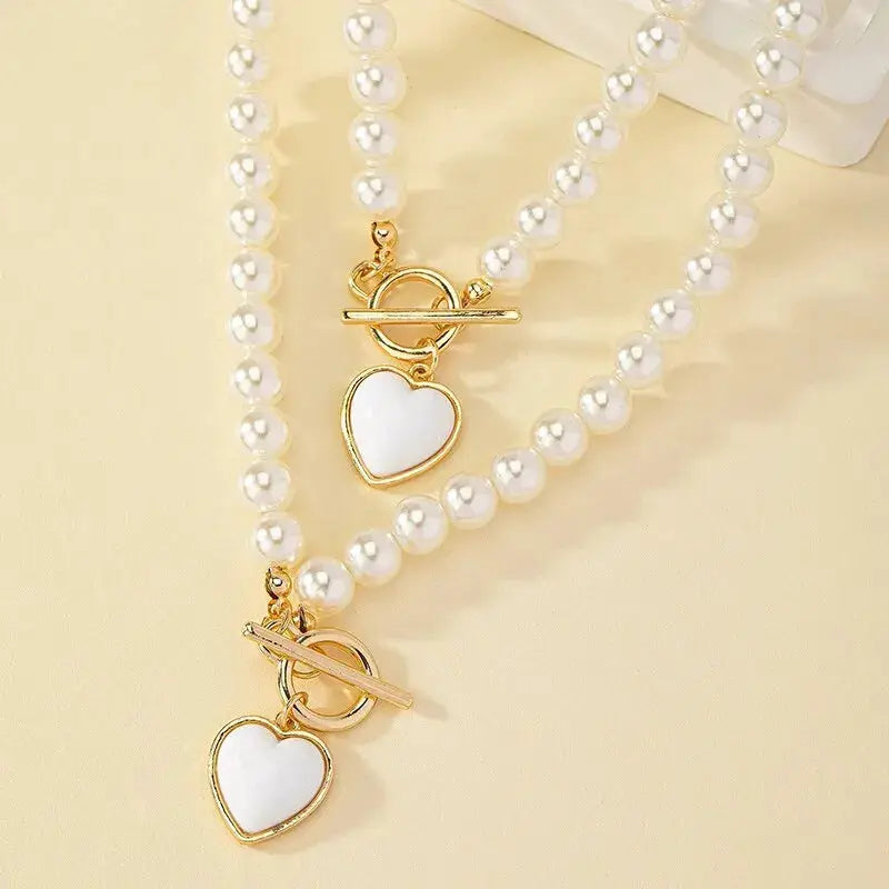 2-Piece imitation pearl jewelry set: necklace and bracelet with white pearls and gold heart pendants
