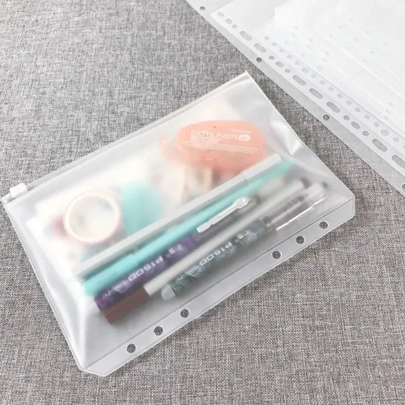 Clear plastic zipper pouch with assorted pens, tape and supplies inside