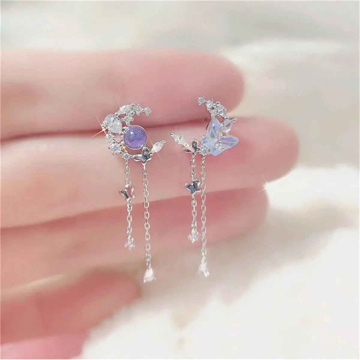 Moon Planet Butterfly Tassel Drop Earrings pair; silver-tone with crystals, purple bead and blue butterfly charms.