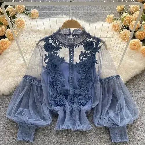 Blue lace puff long-sleeve blouse with sheer sleeves and floral embroidery, high neck and gathered hem.