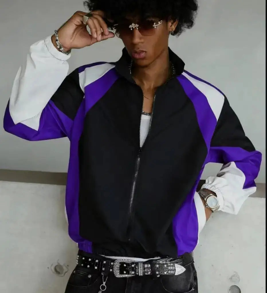 Men's color-blocked lightweight windbreaker jacket in black with purple and white panels; zip-front, casual travel wear.