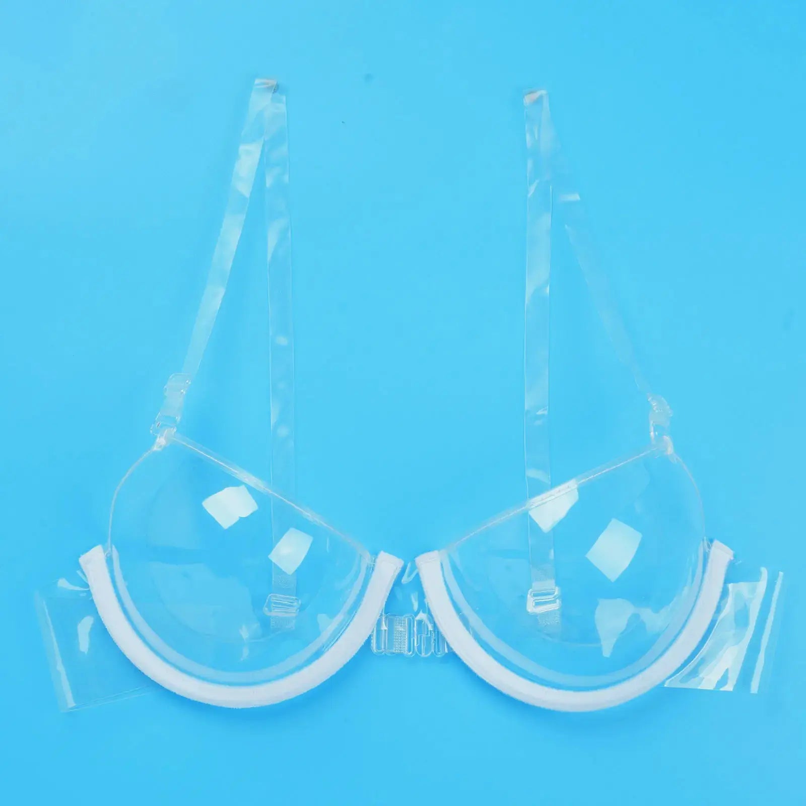 Clear PVC bra top with white trim, in plastic packaging