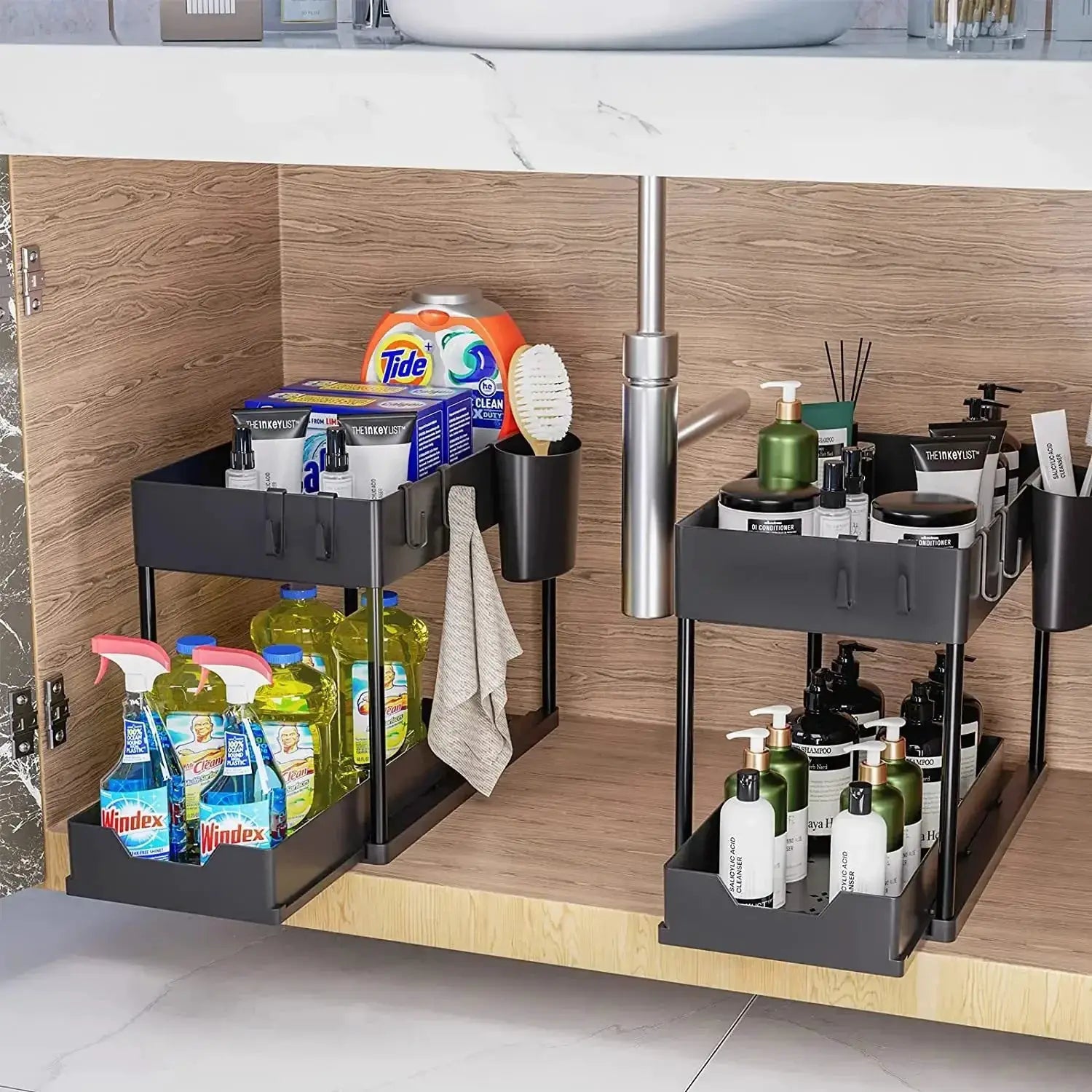Two gray under-sink 2-tier sliding storage racks with black legs and hanging hooks