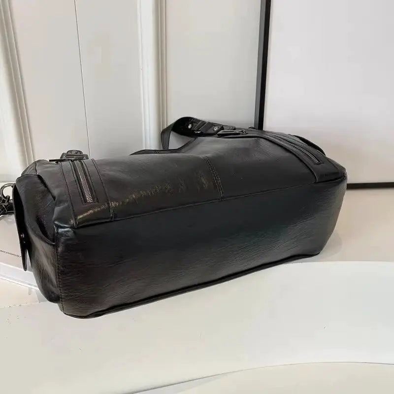 Black PU leather shoulder bag with crossbody strap and soft interior compartment.