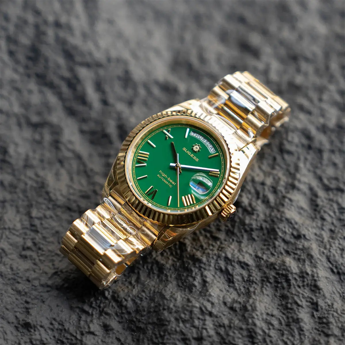 Sugess gold-tone men's 40mm watch with green dial, day and date display, sapphire glass, metal bracelet