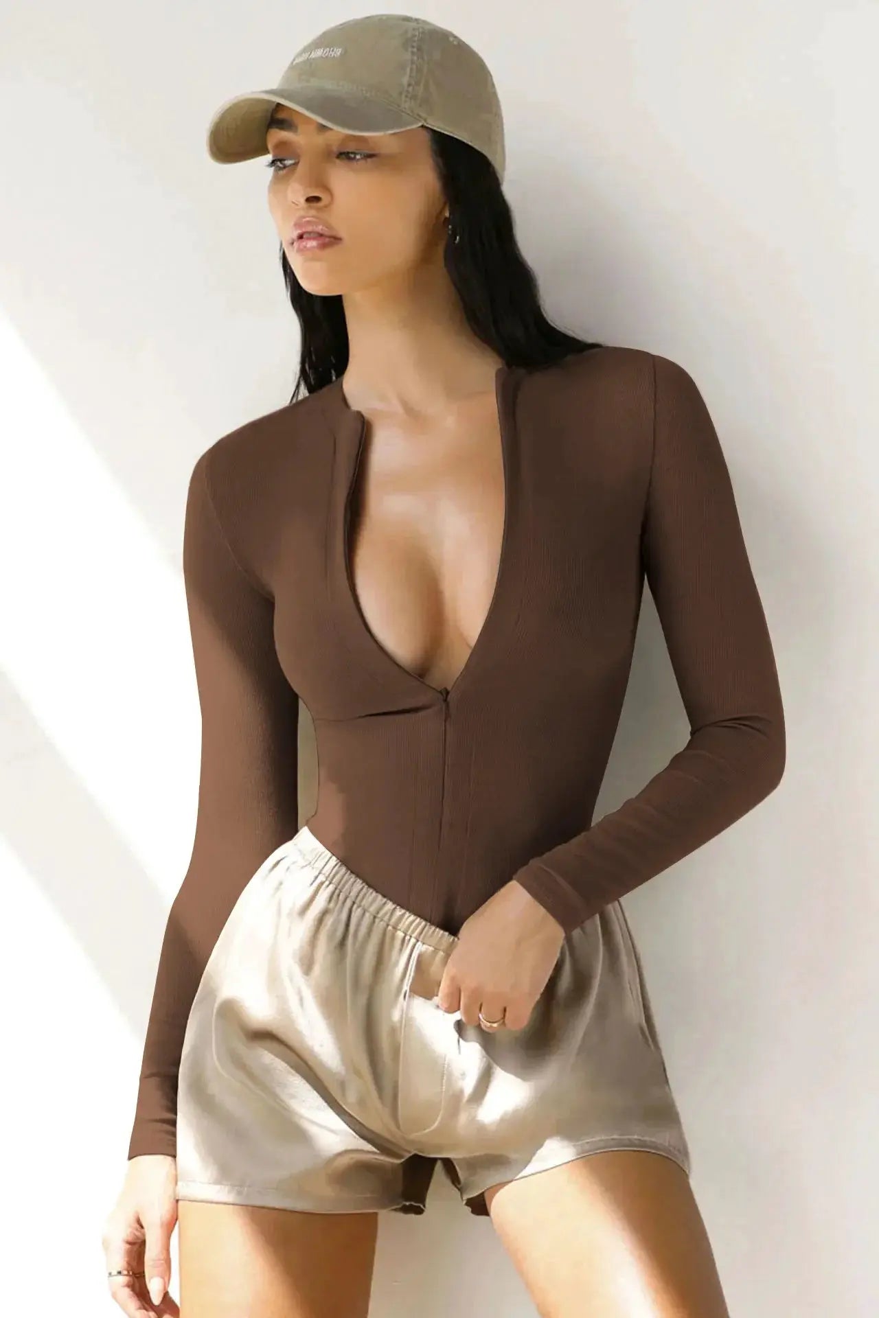 Women’s brown knit jumpsuit with long sleeves, front zipper and deep V-neck.