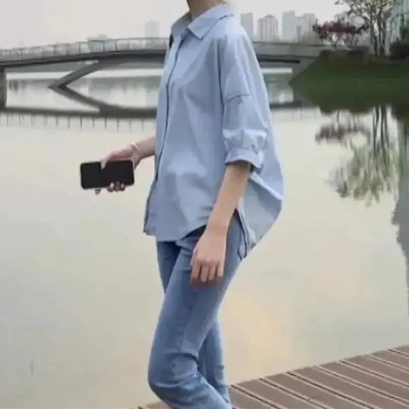 Summer shirt for women in light blue, loose mid-sleeve top paired with jeans on a woman