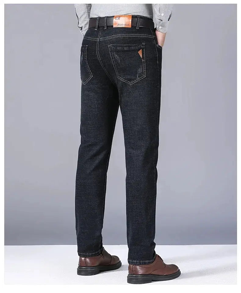 Men's straight jeans in dark indigo stretch denim with back pockets and brown leather belt.