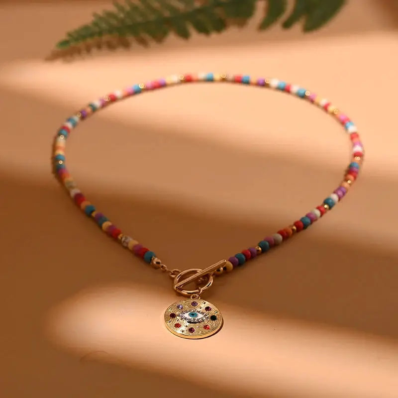 Colorful beaded choker necklace with a gold-tone round evil-eye pendant