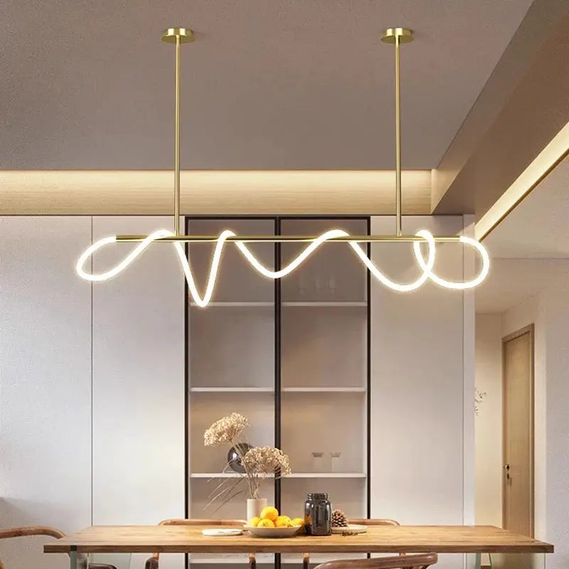 Chandelier in gold Nordic style with looping LED pendant light over a dining table