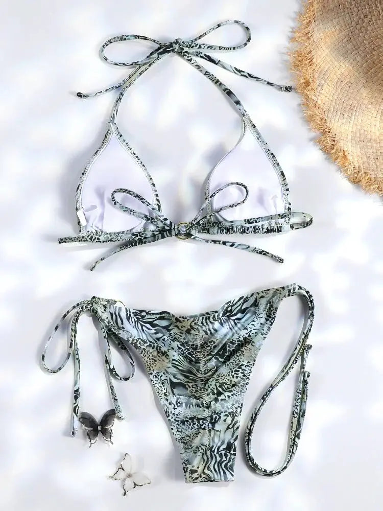 Triangle bikini set by Simples Market with white top and animal-print bottom, adjustable tie sides.