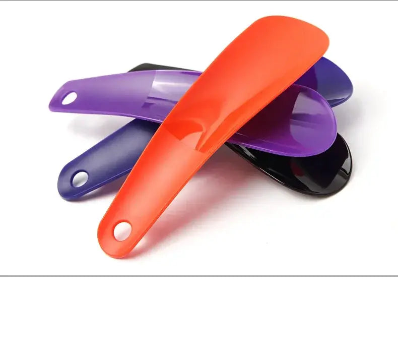 Set of four short-handle plastic shoe horns, 16 cm, in orange, purple, blue, and black.