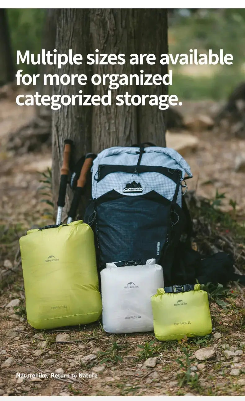 Naturehike vacuum compression storage bags set of 3 in lime, white and yellow-green with a blue backpack outdoors.