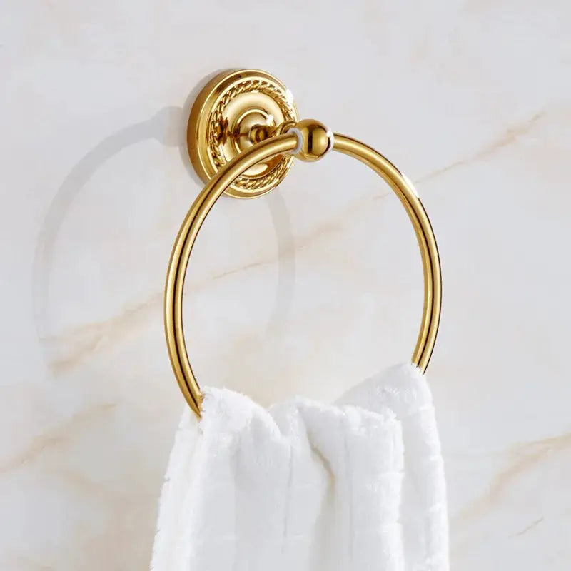 Towel ring by Simples Market in gold brass on a wall mount with a white towel