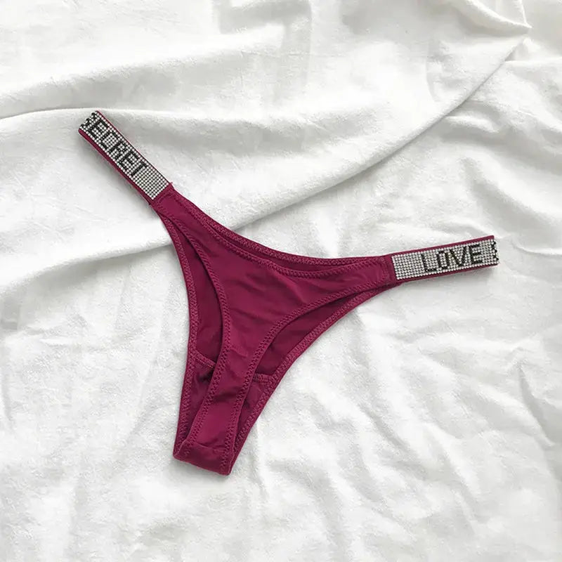 Simples Market magenta low-waist thong with rhinestone straps featuring LOVE lettering