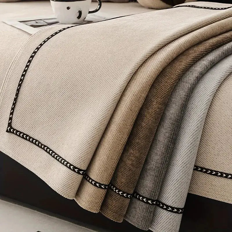 Sofa slipcover in cream chenille with black braided trim; layered beige to gray color swatches.
