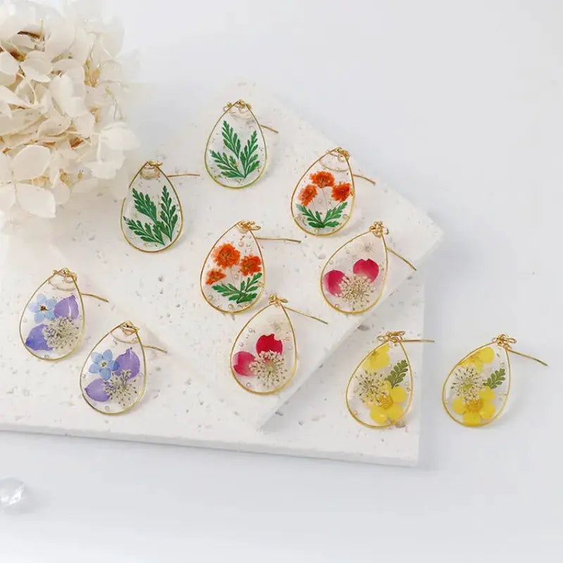Teardrop pressed flower epoxy resin earrings in gold-tone frame, assorted colors by Simples Market