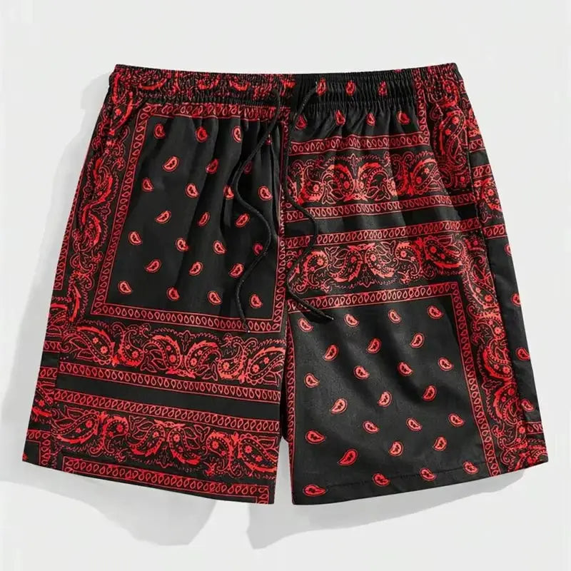 Men's bandana-print beach shorts in black with red paisley pattern and drawstring waist.