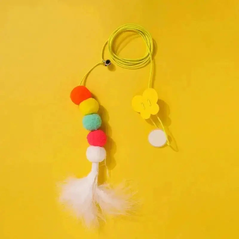 Feather Ball Caterpillar Cat Toy with colorful pom-poms and white feathers on a yellow cord