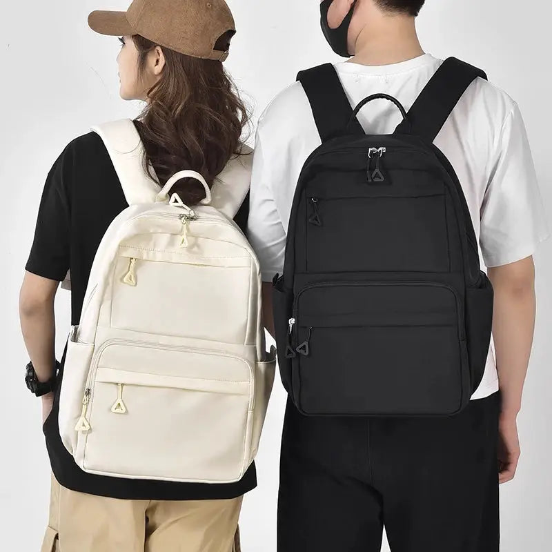 Two casual student backpacks, cream and black, large-capacity unisex laptop backpacks.