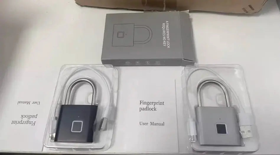 Two fingerprint padlocks with USB charging cables in packaging (black and gray).